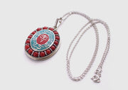 Coral Inlaid Buddha Eyes and Tibetan Om Painted White Metal Pendant - nepacrafts