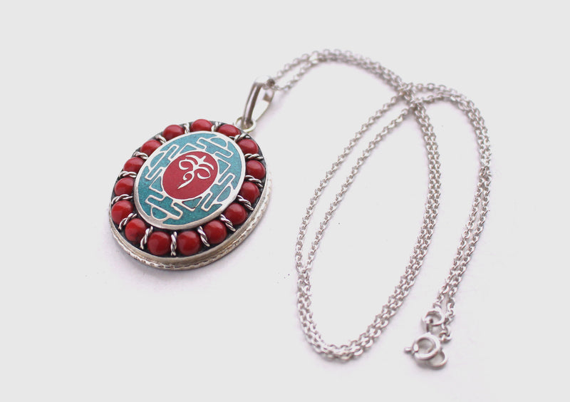 Coral Inlaid Buddha Eyes and Tibetan Om Painted White Metal Pendant - nepacrafts