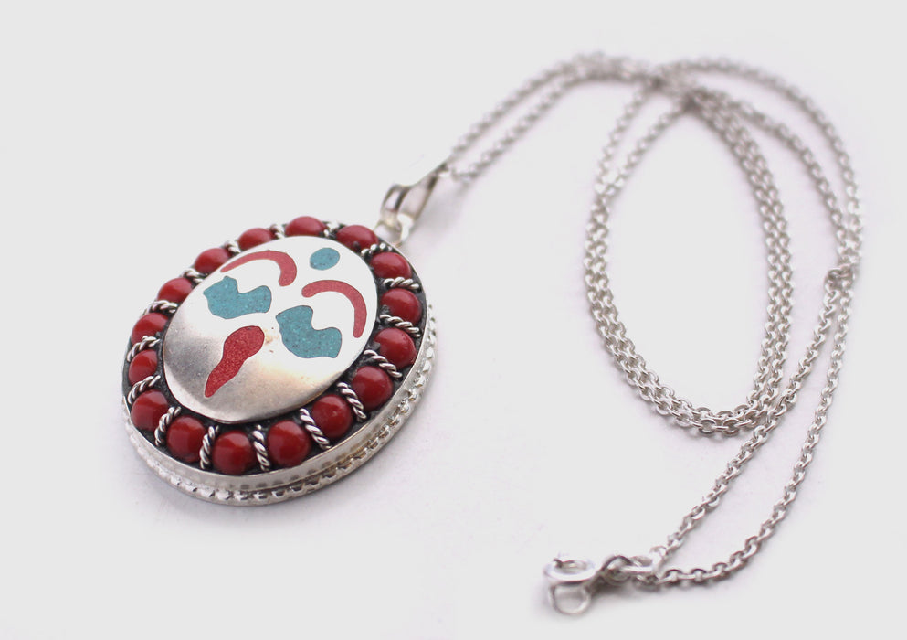 Coral Inlaid Buddha Eyes and Tibetan Om Painted White Metal Pendant - nepacrafts